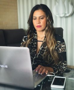 Foto de Ana Maria de Sousa usando um laptop com celular ao lado